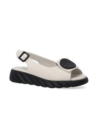 Beige leren slingback schoenen met een zwart afgerond accent, open teen en een golvende zwarte zool. Verstelbare gesp voor een veilige pasvorm.
