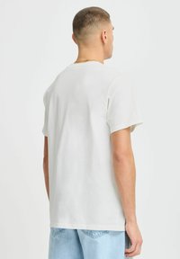 Lys grå bomulls T-skjorte med rund hals og kortermet, med en avslappet passform og enkel tekstur. Bakside viser et enkelt design.