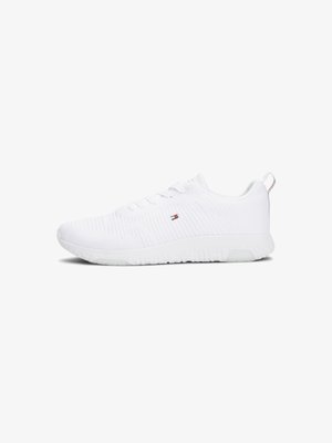 White athletic shoe with a textured mesh upper, lace-up design, and a patterned rubber sole. Features a small logo accent on the side.
