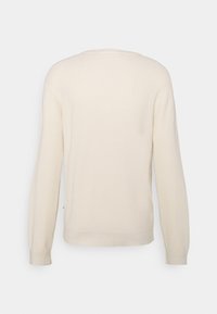 Pull en maille gaufrée à manches longues couleur blanc cassé avec des poignets et un ourlet côtelés, montré de dos sur fond blanc.