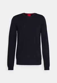 Granatowy sweter z dekoltem w łódkę, długimi rękawami, prążkowanymi mankietami i dołem, wykonany z miękkiego materiału. Z czerwonym logo na metce przy szyi.