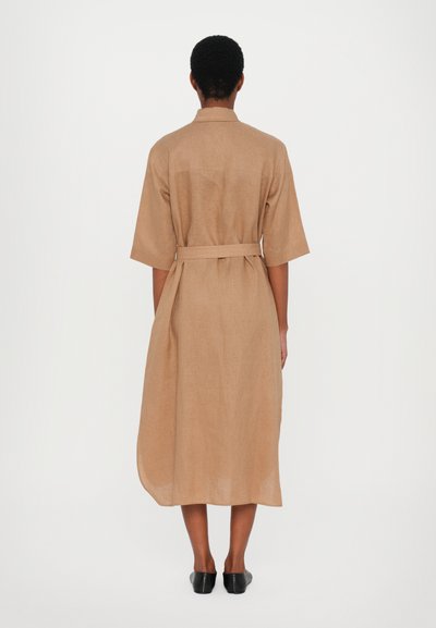 Vestido bege de linho de comprimento médio com mangas curtas, cintura cingida e silhueta reta. Design minimalista, textura suave.