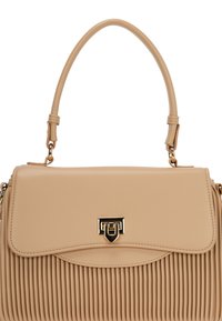 Beige håndtaske med ribbet tekstur, en struktureret form og en beslag i guldfarve. Inkluderer et håndtag på toppen og diskrete syninger.