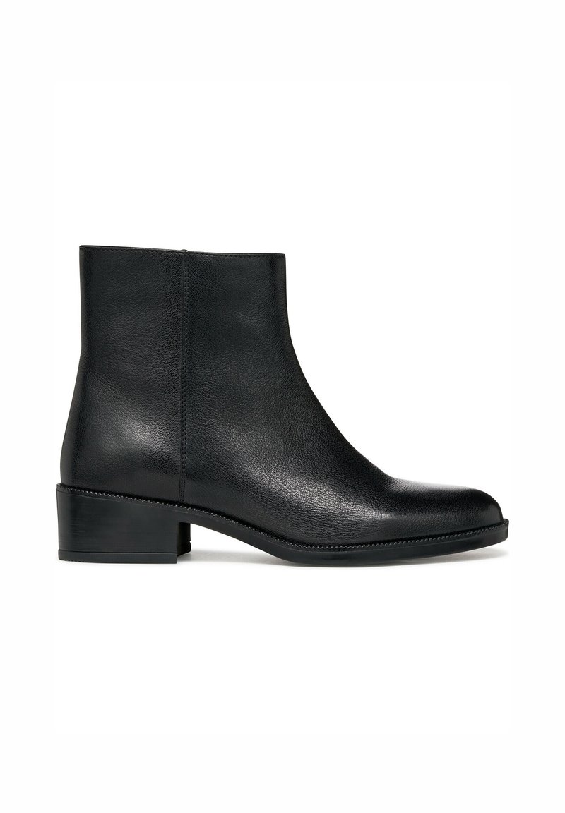 Bottes de cheville en cuir noir avec un bout rond, un petit talon carré et un subtil détail de couture le long de la semelle. Texture lisse, design minimaliste.