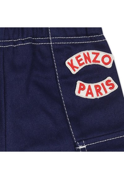 Shorts in denim blu navy con cuciture bianche e due toppe ricamate rosso e bianco con la scritta "KENZO" e "PARIS."
