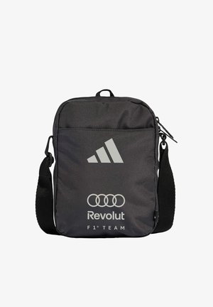 Black shoulder bag with Adidas logo, Audi rings, Revolut text, and F1 Team branding on the front pocket, adjustable strap on the side.