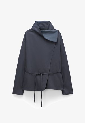 Giacca avvolgente grigio scuro con colletto alto, davanti asimmetrico e cintura annodata in vita, mostrata su sfondo bianco.