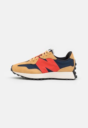 Zapatilla casual con ante color tostado, tejido azul marino, gran logo rojo en el lateral, entresuela blanca y suela exterior de goma negra con cordones.
