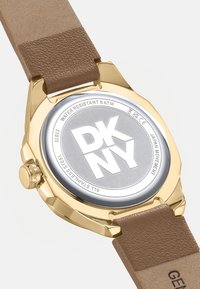 Gouden stainless steel horloge met een ronde zilveren kast, bruine leren band en een waterdichte constructie tot 5 ATM.