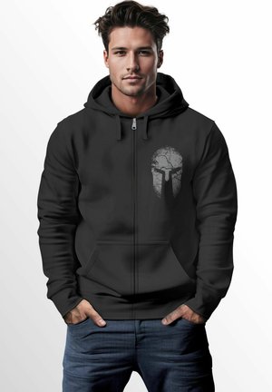 Black zip-up hoodie with a front pocket and a cracked spartan helmet graphic in gray on the left chest area. Smooth texture, casual fit.