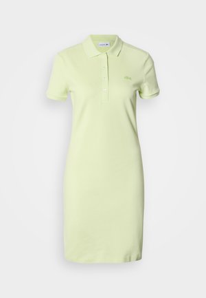 Helerohelisest puuvillast polokleit, millel on klassikaline krae, lühikesed varrukad, nööbitav esikülg ja rinnal tikitud logo.