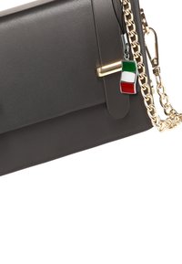 Graue Handtasche aus synthetischem Leder mit einem goldfarbenen Kettenriemen, versehen mit einem dekorativen Anhänger in Form der italienischen Flagge und einem eleganten Verschluss.