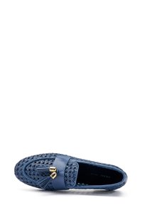 Mocassini blu con tomaia intrecciata e banda in pelle liscia con dettagli in metallo dorato e frange decorative. Design con suola piatta.