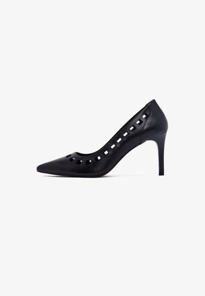 Black leather high-heeled pump with pointed toe, cut-out details along the edge, and a sleek design. Smooth texture and tapered heel.