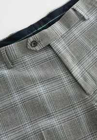 Grau karierte Hose mit Knopfverschluss, strukturiertem Taillenbund und kontrastierendem marineblauem Innenfutter. Hergestellt aus strukturiertem Stoff.