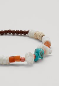 Kralenketting met bruine houten kralen, witte en oranje accenten, en turkooise vormen met een gladde textuur.