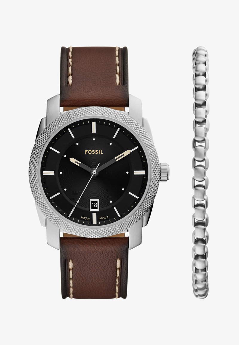 Fossil watch with black circular dial, silver case, brown leather strap with beige stitching, and a silver bracelet on the side.