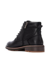 Botín negro de cuero hasta el tobillo con cremallera lateral, acentos texturizados en el tacón y suela de aspecto madera en un tono marrón. Diseño de cordones con herrajes plateados.