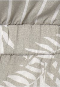 Lichtgrijze stof met een bladpatroon in het wit. Heeft een geplooide stiksel detail langs de naad, wat textuur en visuele interesse creëert.