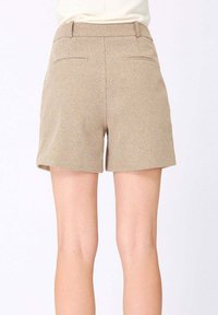 Shorts beiges avec un motif à carreaux texturé, présentant une coupe droite, des poches latérales et une taille.