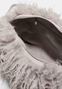 Sac à main flou, gris clair, avec un extérieur texturé et une fermeture éclair argentée. L'intérieur dispose d'une doublure lisse et d'une petite poche zippée.