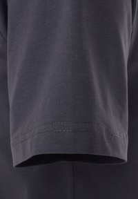 Donkergrijze katoenen t-shirt met korte mouwen, voorzien van een gladde textuur en nette stiksels langs de zoom.