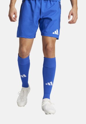 Blauwe sportshorts met ribbeltextuur en wit logo, gecombineerd met blauwe sokken voor voetbalsport met een wit streep patroon, en witte voetbalschoenen.