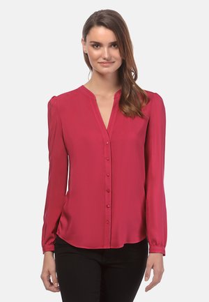 Blusa a maniche lunghe di un rosso intenso con bottoni sul davanti, scollatura a V e dettagli arricciati sulle spalle; texture liscia con una leggera lucentezza.
