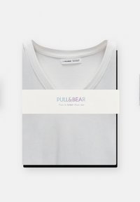 Bílé tričko s výstřihem do V, úhledně složené, vyrobené z měkké látky, s viditelnou štítkem značky "PULL&BEAR". Obsahuje štítek značky a obal.