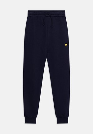 Pantalon de survêtement bleu marine en tissu doux, avec une taille élastique et un cordon de serrage, et un petit logo jaune sur la cuisse gauche.