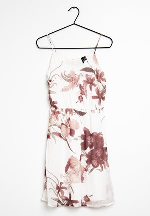 Robe fleurie sur un cintre. Le tissu est léger avec une base blanche et des motifs floraux dans des tons de bordeaux et de rose clair. Bretelles réglables.