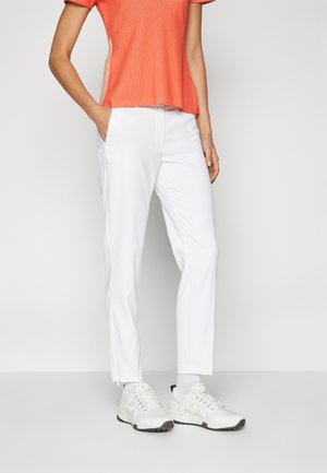 White trousers with a tailored fit, polyester material, side pockets, and a subtle zipper detail at the hem, paired with a textured orange top.