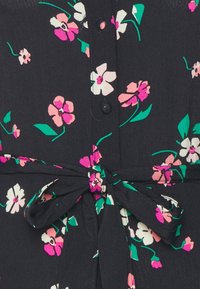Černá látka s růžovým, bílým a zeleným květinovým vzorem, s předním zapínáním na knoflíky a detailem vázan�ého pasu. Lehký a texturovaný materiál.