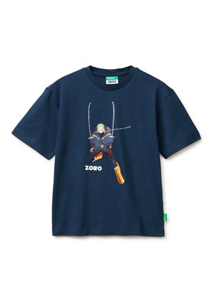 Camiseta azul marino con un personaje empuñando tres espadas en una pose de acción y el nombre "Zoro" impreso debajo.