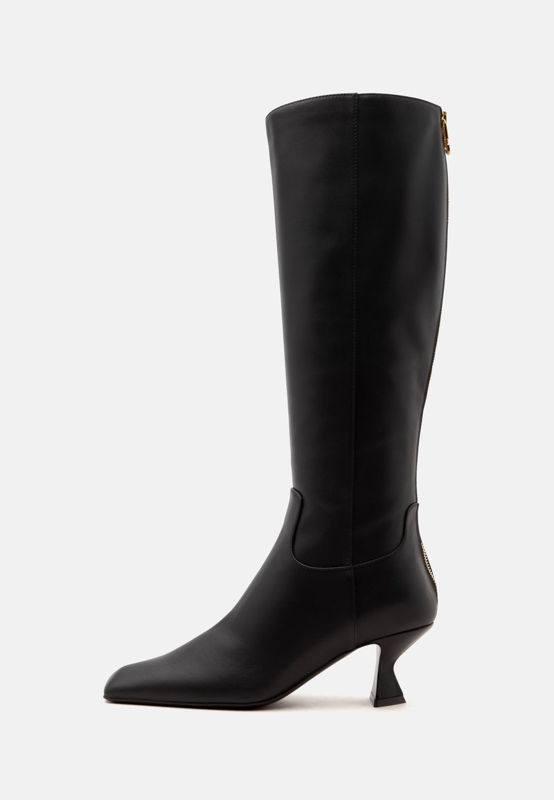 Botte en cuir noire montant jusqu'au genou, avec bout pointu, fermeture éclair latérale et talon évasé de hauteur moyenne, présentée sur fond blanc.