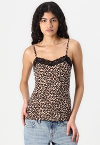 Leopardmönstrad linne i mjuk tyg med spetsdetaljer längs halsringningen och justerbara spaghetti-bandsaxlar. Har en figurnära silhuett.
