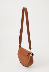 Smeđi kožni crossbody torba s podesivim remenom i zlatnim detaljima, prikazana na jednostavnoj bijeloj pozadini.