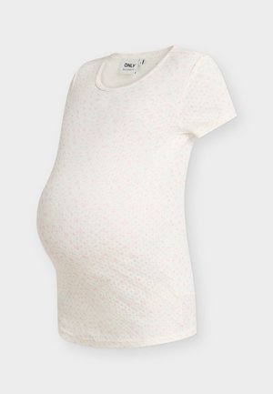 Maglietta premaman bianca a maniche corte con piccolo motivo floreale rosa e scollo rotondo su sfondo neutro.