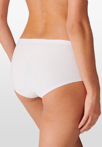 Culotte hipster en coton blanc avec un design lisse et sans coutures, dotée d'une large ceinture, présentant une texture subtile et un minimum de détails.
