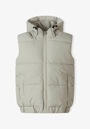 Gilet matelassé beige clair avec fermeture éclair à l'avant, capuche avec cordon de serrage et deux poches latérales. Présente une texture matelassée et un ourlet élastiqué.