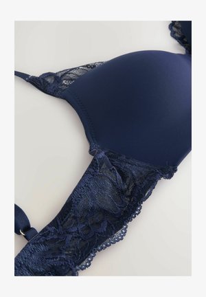 Marineblauer BH mit gepolsterten Cups, verziert mit Spitzenbesatz und gewellten Kanten. Glattes Material mit dekorativen Spitzenakzenten an den Seiten.