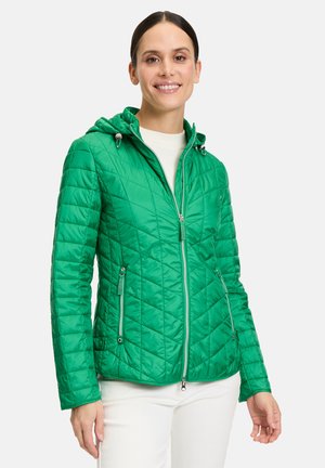 Grüne Steppjacke mit Kapuze, Reißverschluss vorne und seitlichen Taschen. Hergestellt aus leichtem Material und mit einem geometrischen Stickmuster versehen.