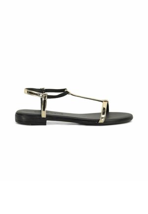 Sandalo piatto nero con sottili cinturini metallici dorati e cinturino posteriore alla caviglia, progettato per uno stile minimalista e aperto.