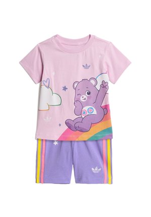 Tenue pour enfants avec un t-shirt rose représentant un ours violet qui fait un clin d'œil sur un arc-en-ciel et un short violet avec des rayures roses et jaunes.