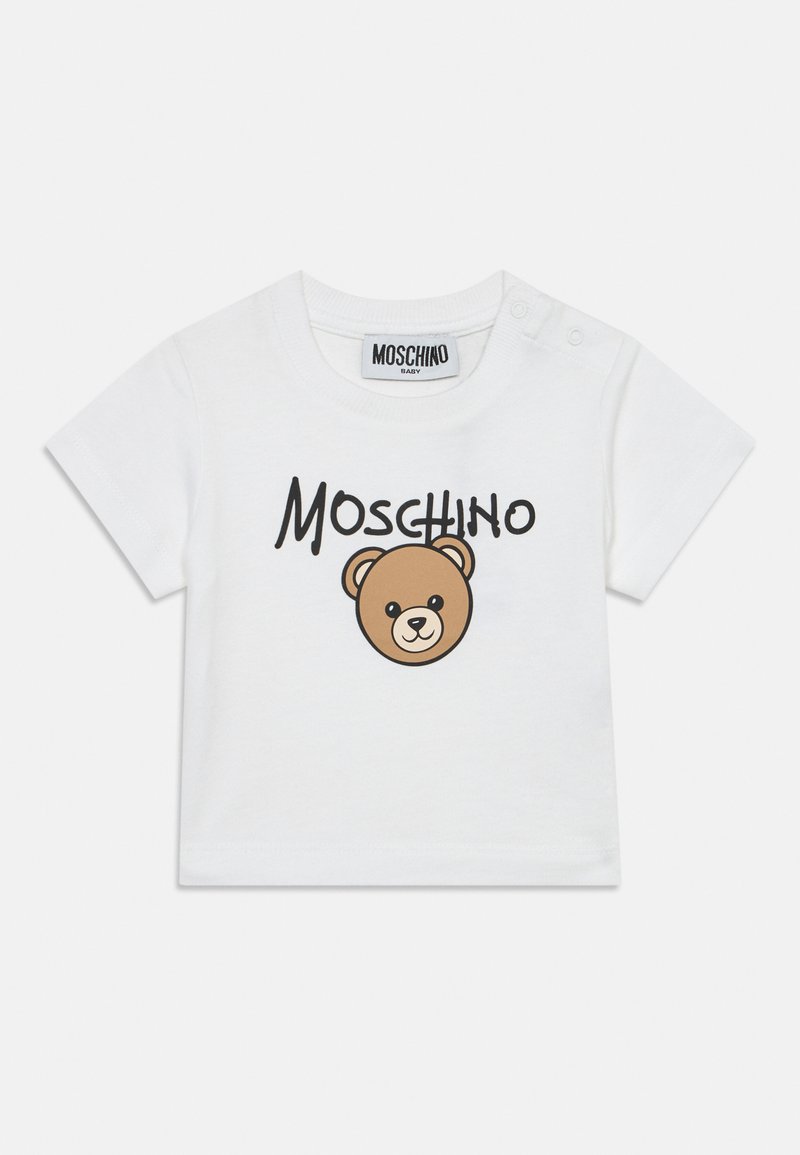 Λευκό βρεφικό T-shirt με κοντά μανίκια, λογότυπο Moschino και ένα χαριτωμένο πρόσωπο αρκούδας τυπωμένο μπροστά.