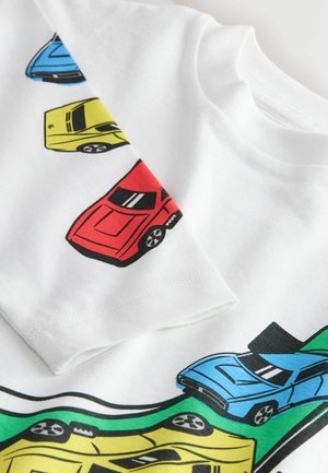 White cotton t-shirt featuring colorful car graphics in red, blue, yellow, and green. Classic fit with round neckline and short sleeves.