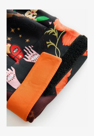 Flerfarvet stof med blomster- og mystiske mønstre, med en orange stofdetalje og sort velcro. Teksturen virker glat.