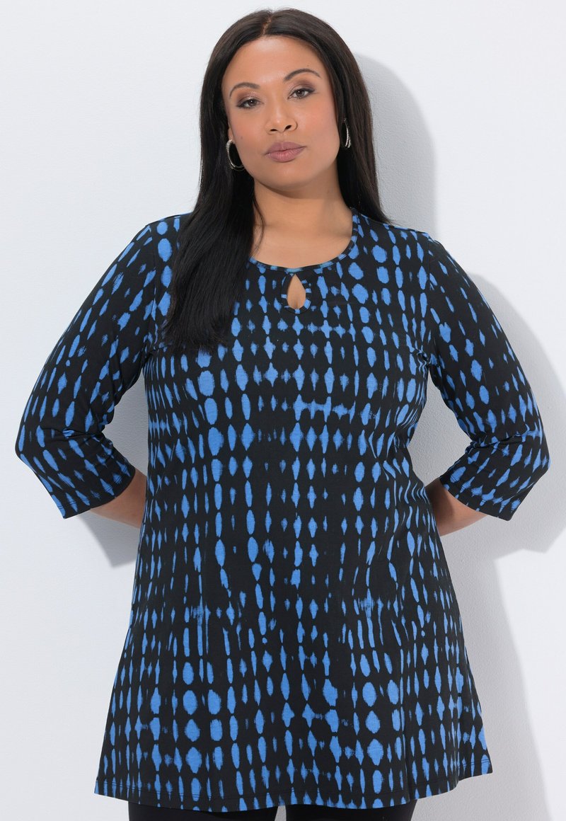 Sort tunika med blåt mønster, med halsudskæring i nøglehul og trekvartlange ærmer. Blødt stof, løs pasform og tekstureret design.