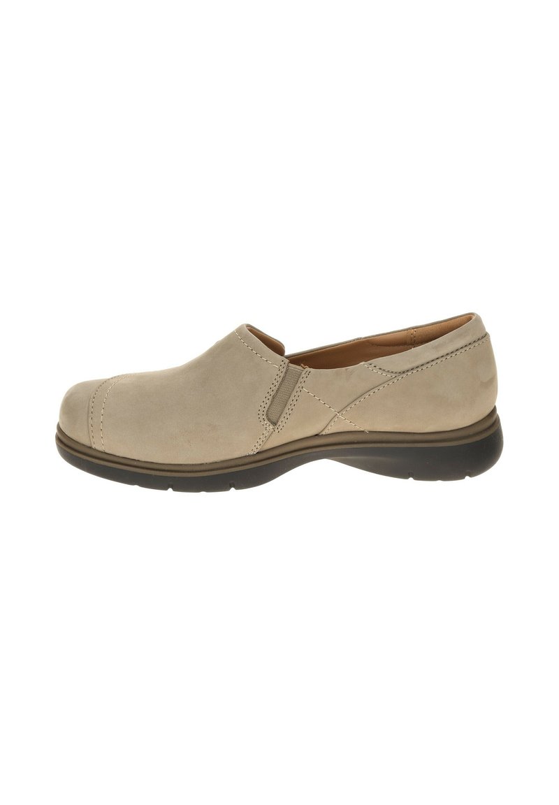 Beige suede slip-on shoe with rounded toe, subtle stitching details, and a low, black rubber outsole. Minimalist design for versatility.