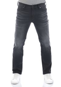 Jeans in denim grigio scuro con una linea dritta, leggera scoloritura, cinque tasche e dettagli in metallo. Indossati con sneakers bianche.